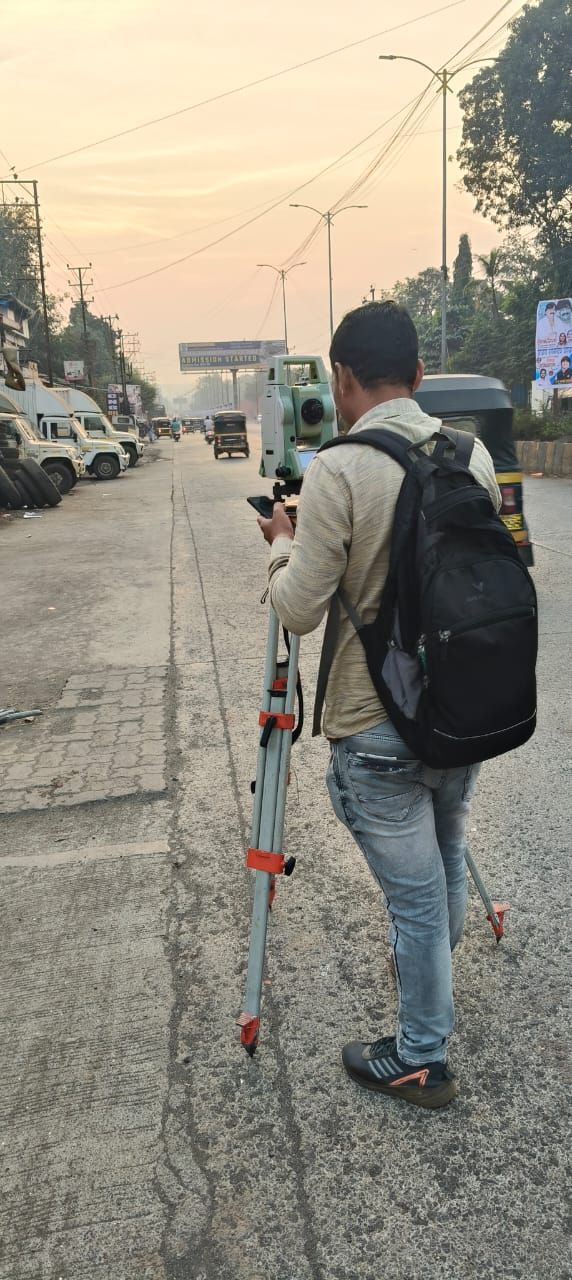 Surveyor holding a levelling staff on a Kailash Nagar road